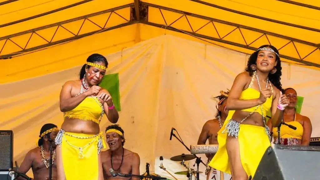 Karifuna dancers performing in bright yellow costumes at a festival