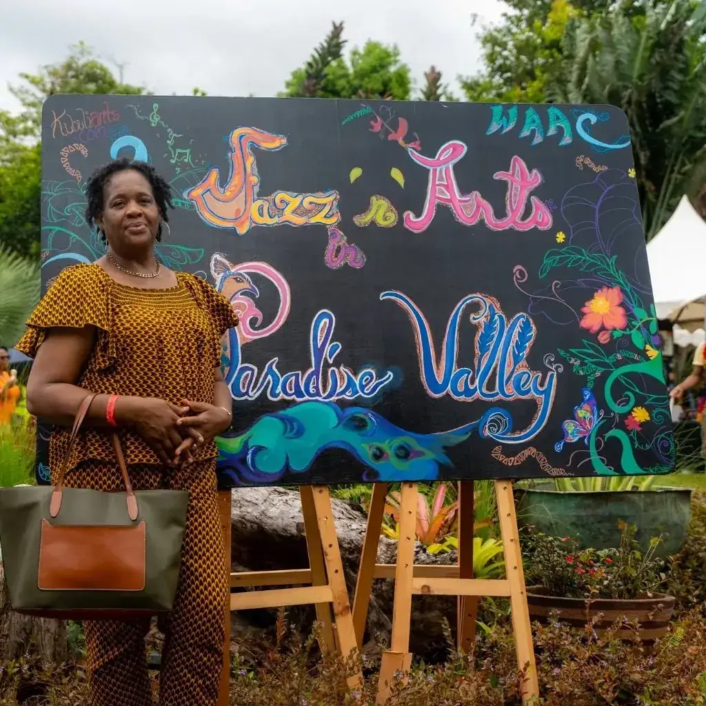 A guest beside the hand-painted Jazz 'n Arts in Paradise Valley sign
