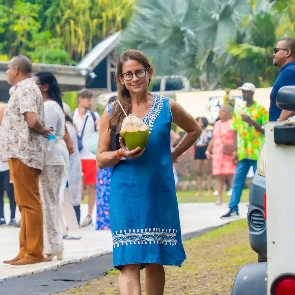 A festival-goer enjoying a fresh coconut among the crowd