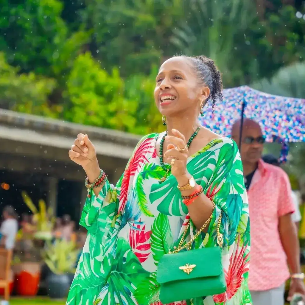 A guest in a vibrant tropical print dress laughing at the Jazz & Arts festival