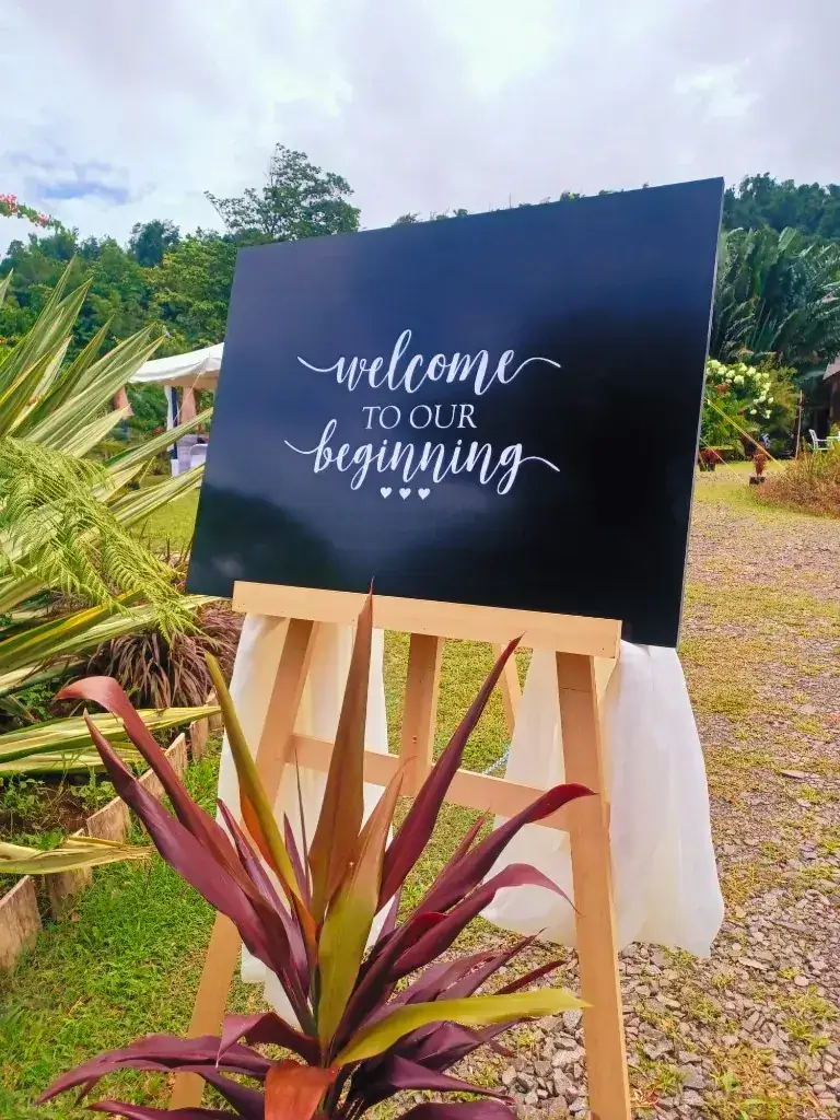 A welcome sign on an easel among tropical planting at a wedding on the Paradise Valley grounds